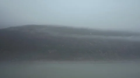 Fog over a forested mountainside with a small waterfall Stock-Footage 348017886