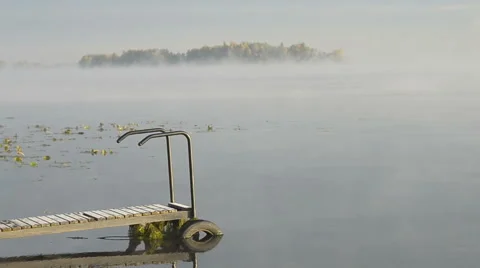 Fog over the water and the guy on the bridge Stock Footage 55702223