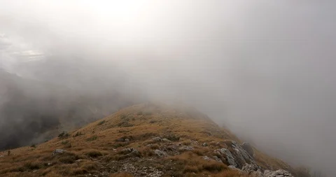 Fog passing a ridge at the top of a mountain with autumn weeds Stock Footage 120688437