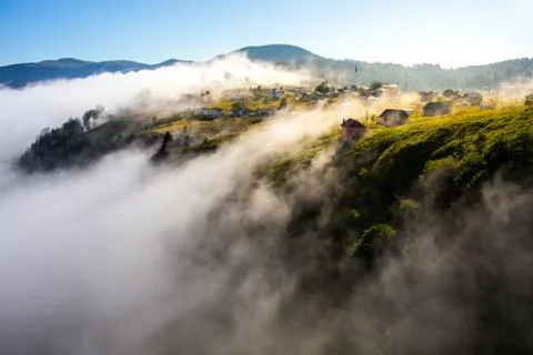 The fog rises from the depths and covers the village. Stock Photos