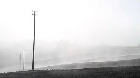 Fog rising in Tuscan worked fields with overhead power line Stock Footage 82389730
