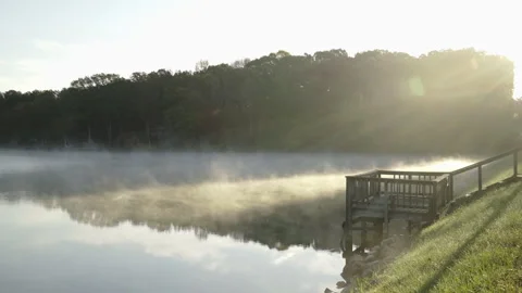 Fog rolling across lake with dock Stock Footage 264219906
