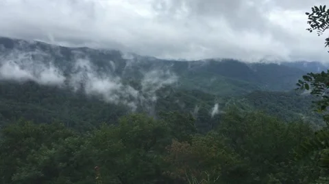 Fog rolling over clear mountains Видео 53500236