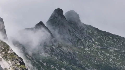 Fog rolling over mountain peaks and cliffs Stock Footage 300938780