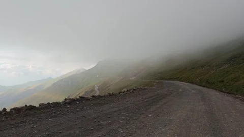 Fog rolling over mountain road in Tusheti National Park, Georgia Видео 315360369
