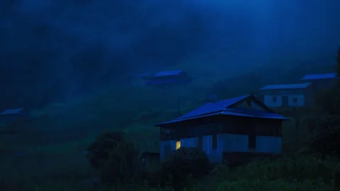Fog rolling over a remote rural village at night 스톡 동영상 335495415