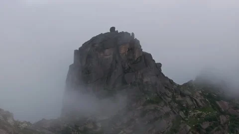 Fog rolling over rocky mountain peak Stock Footage 300937274