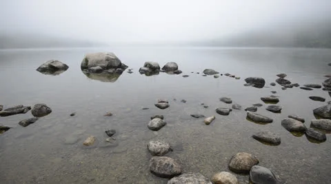 Fog rolling in over stones in a pond. Stock Footage 25588708