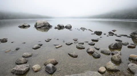 Fog rolling in over stones in a pond. Stock Footage 25588847