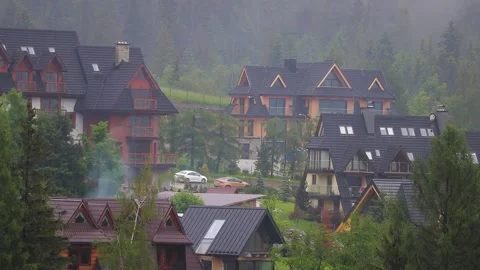 Fog rolling through a mountain forest with few visible village houses. Fogg.. Vídeos de archivo 329063832