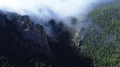 Fog rolls over the mountains into the valley in Colorado Stock Footage 247363934