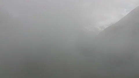 Fog slowly dissolving, revealing mountain landscape Stock Footage 289655088
