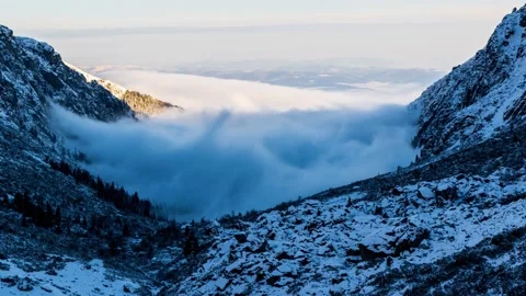 Fog in the valley between snowy mountians Stock Footage 132240825