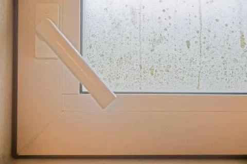 Fogged bathroom window with handle down and closed tight. Stock Photos