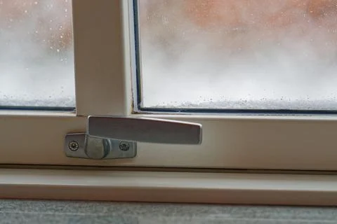 Fogged plastic window with old handle and winter condensation buildup Photos