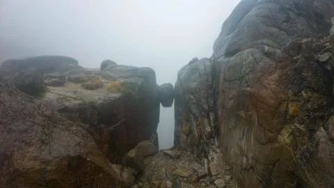 Foggy Cliffs with Boulder Wedged Between Stock Photos