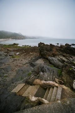 Foggy low tide beach access concrete steps Cornwall coast England Stock Photos