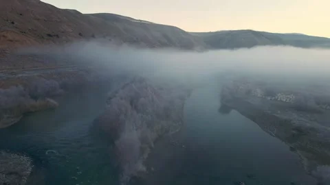 A foggy mountain range with a river running through it Stock Footage 327963666