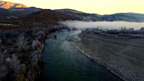 A foggy mountain range with a river running through it Stock Footage 331356319