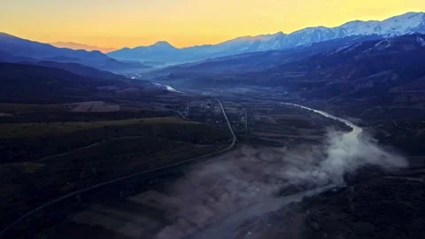 A foggy mountain range with a river running through it Stock Footage 331356683