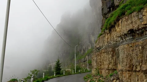 Foggy mountain road snaking along steep cliff Stock-Footage 343995658