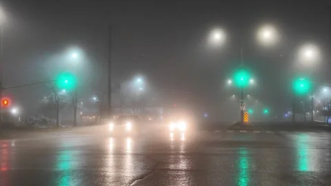 Foggy Night Intersection With Turning Vehicles and Streetlights Stock Footage 301230936