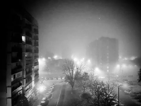Foggy night, lights between the big buildings Stock Photos