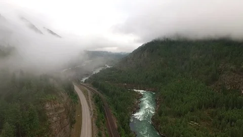 Foggy River flows alongside Road Stock Footage 72688903
