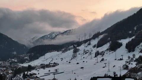 Föhn Fog Rolling Down Alpine Valley at Dusk Over Ski Resort Village Stock Footage 338356733