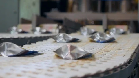 Foil is getting put onto boxes relocated by the transporter. Packing process at Stock Footage 129090555
