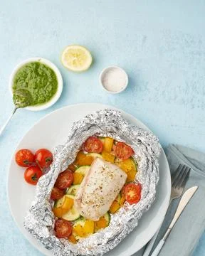 Foil pack dinner with white fish. Oven baked fillet of cod, pike perch with.. Stock Photos