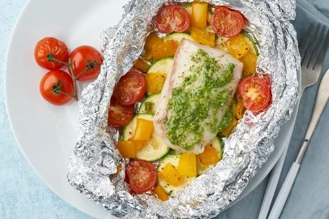 Foil pack dinner with white fish. Oven baked fillet of cod, pike perch with.. Stock Photos