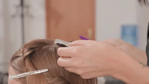 Foil streaks being carefully added, Closeup of hair sectioning and application Stock Footage 327480904