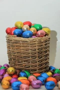 Foil wrapped chocolate easter eggs in a wicker basket Foto stock
