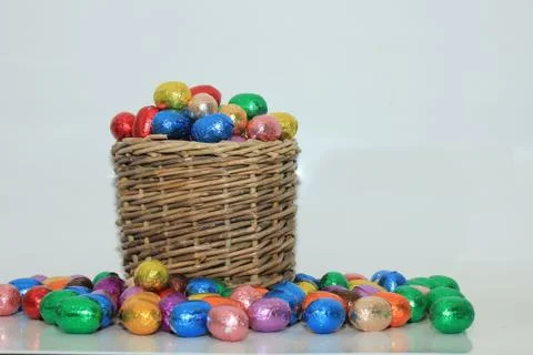 Foil wrapped chocolate easter eggs in a wicker basket Foto stock