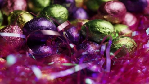 Foil wrapped easter eggs in pink tinsel grass nest Stock Footage 327829522