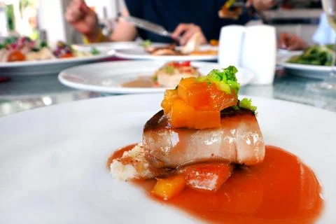 Fois gras in mango mixed fruit sauce served on white plate dish in restaurant Stock Photos
