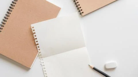 Fold graph paper with spiral notebook, pencil and eraser on white background. Foto stock