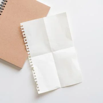 Fold graph paper with spiral notebook on white background. Stock-Fotos