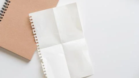 Fold graph paper with spiral notebook on white background. Stock-Fotos