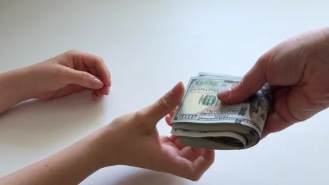 Fold a stack of dollars in half. A stack of 100 dollar banknotes is passed from Stock Footage 345174057