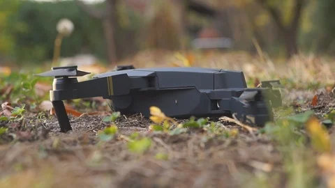 Foldable drone take off from the ground in the garden, left side view Stock Footage 97727500