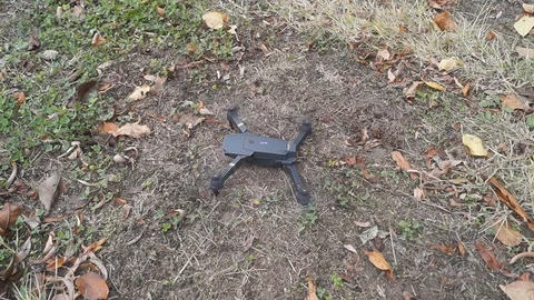 Foldable drone take off from the ground in the garden Stock Footage 97727542