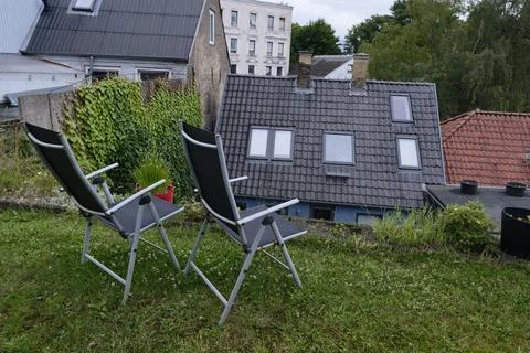 Foldable mesh chairs on hill with view over rooftops and greenery Stock Photos