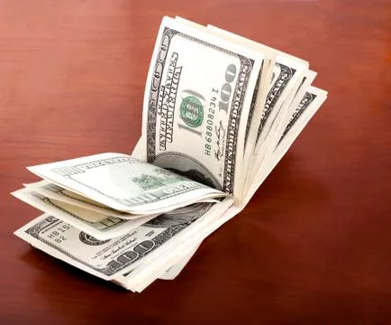 Folded 100 us$  bills stack on brown background 库存插图