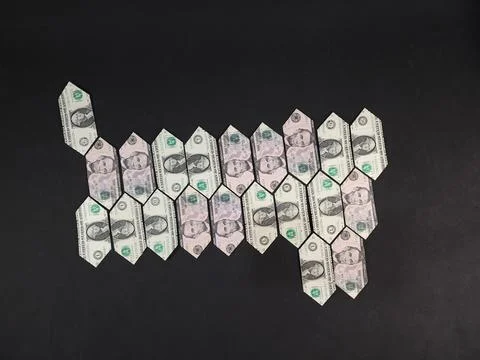 Folded and linked US dollar bills on a black background with space for text Stock Photos