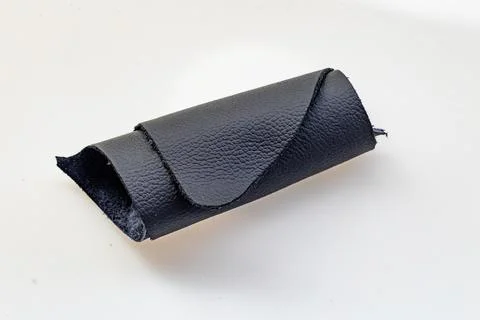 Folded Black Leather Sheet Showing Smooth and Suede Sides on White Backgrou.. Stock Photos