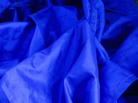 Folded blue fabric cwith soft and flowing lines perfect for texture background Stock Photos