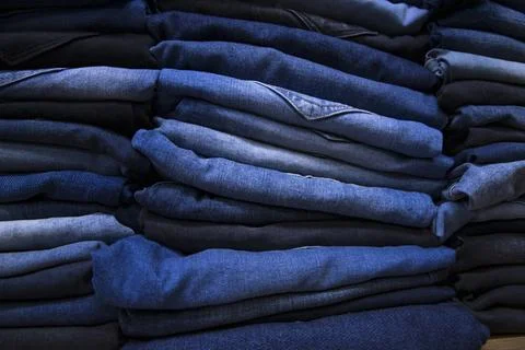 Folded blue jeans pant pattern texture can be used as a background wallpaper Stock Photos