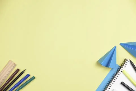 Folded blue papers with office stationeries against yellow backdrop with sp.. Stock Photos